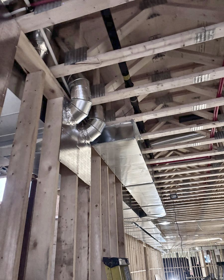 Rectangular trunk and round branch elbows fitted between floor trusses